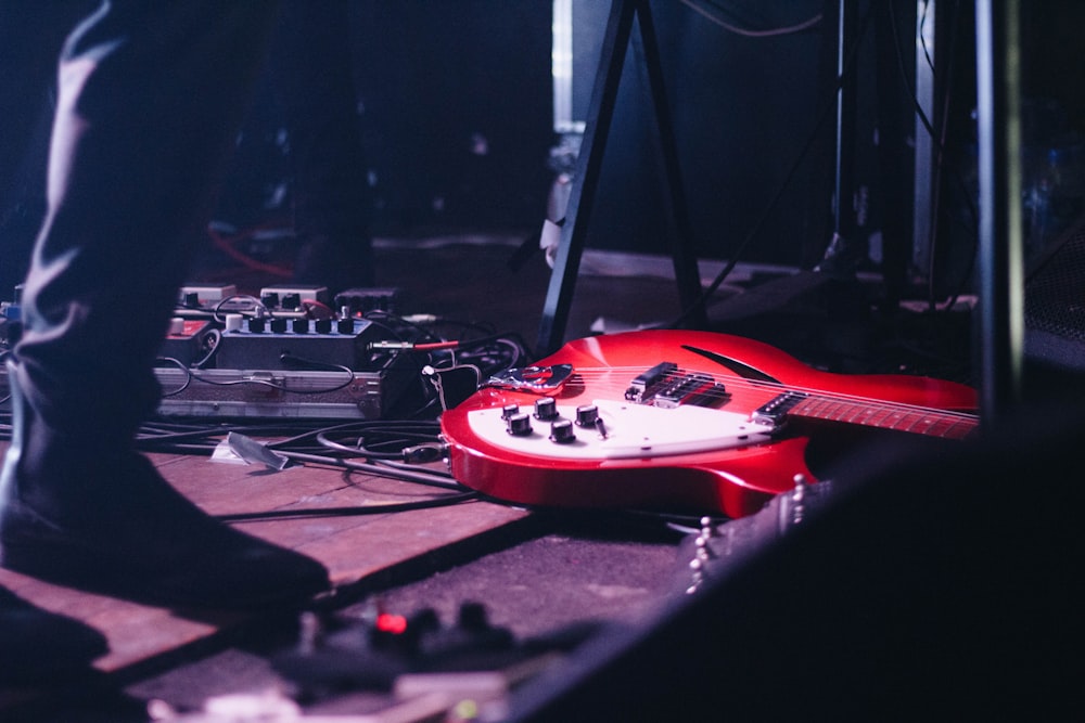 red electric guitar on flooring