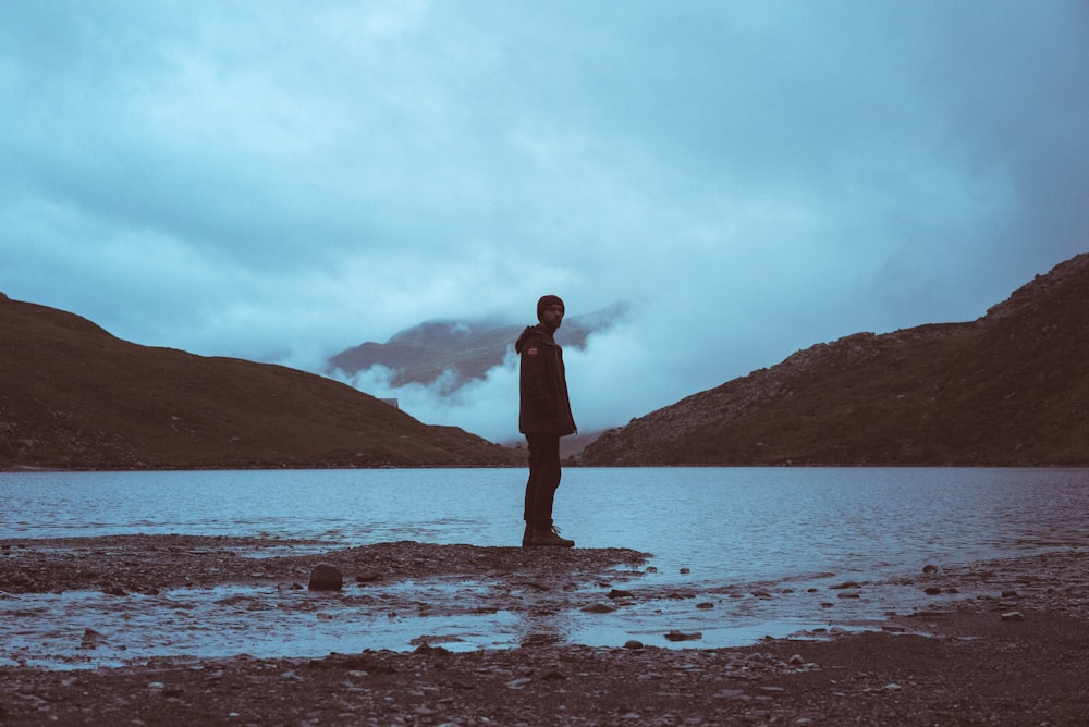 man standing on shoreline