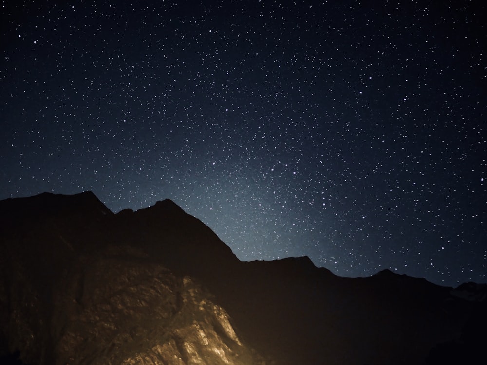 silhouette of mountains under stars