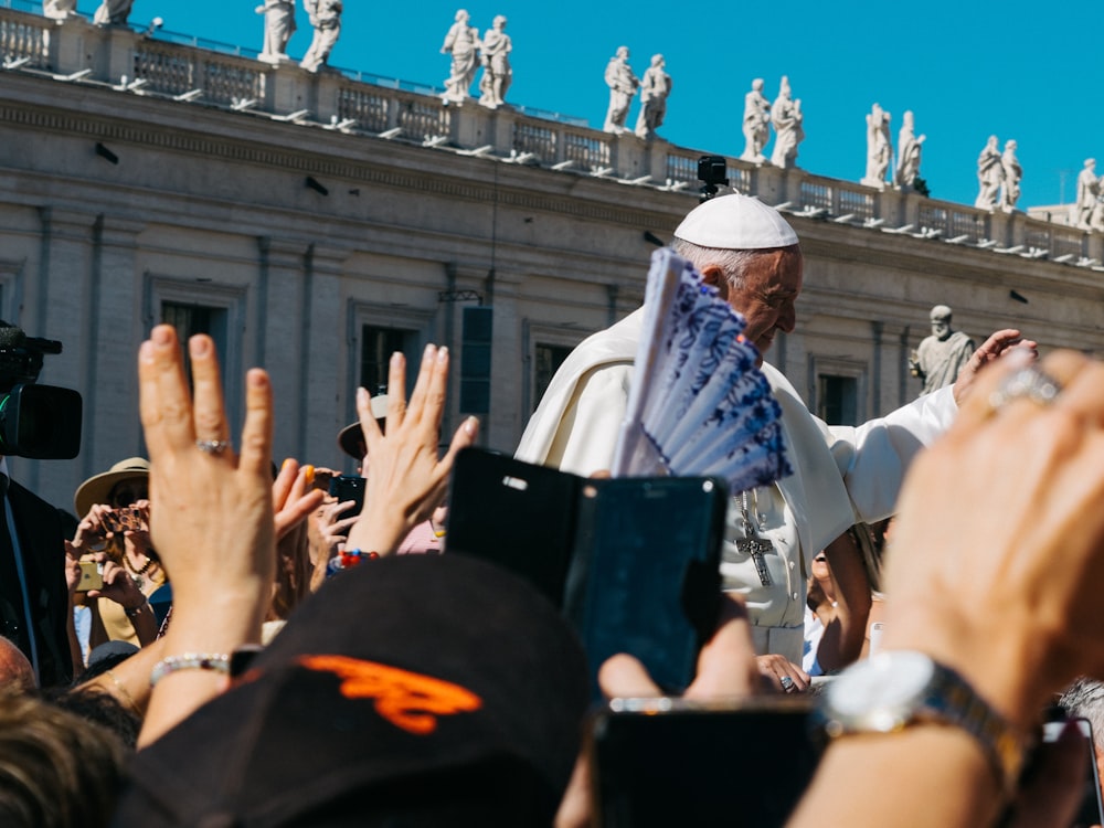 Pope surrounded with people during daytime