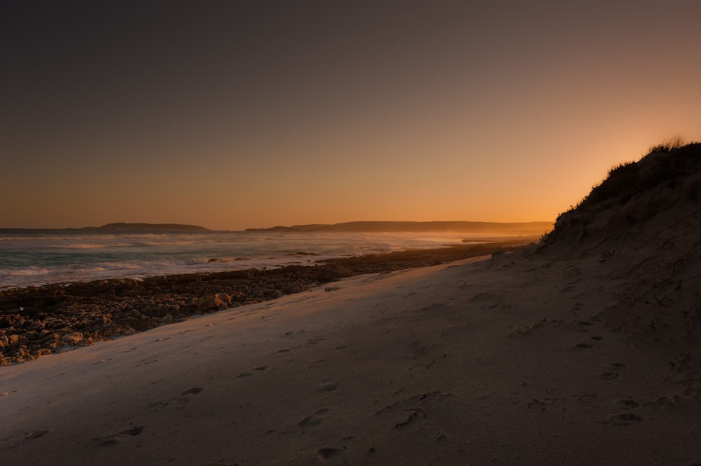 silhouette of hill near body of water