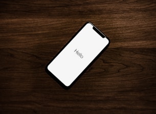 turned on iPhone on top of brown wooden surface