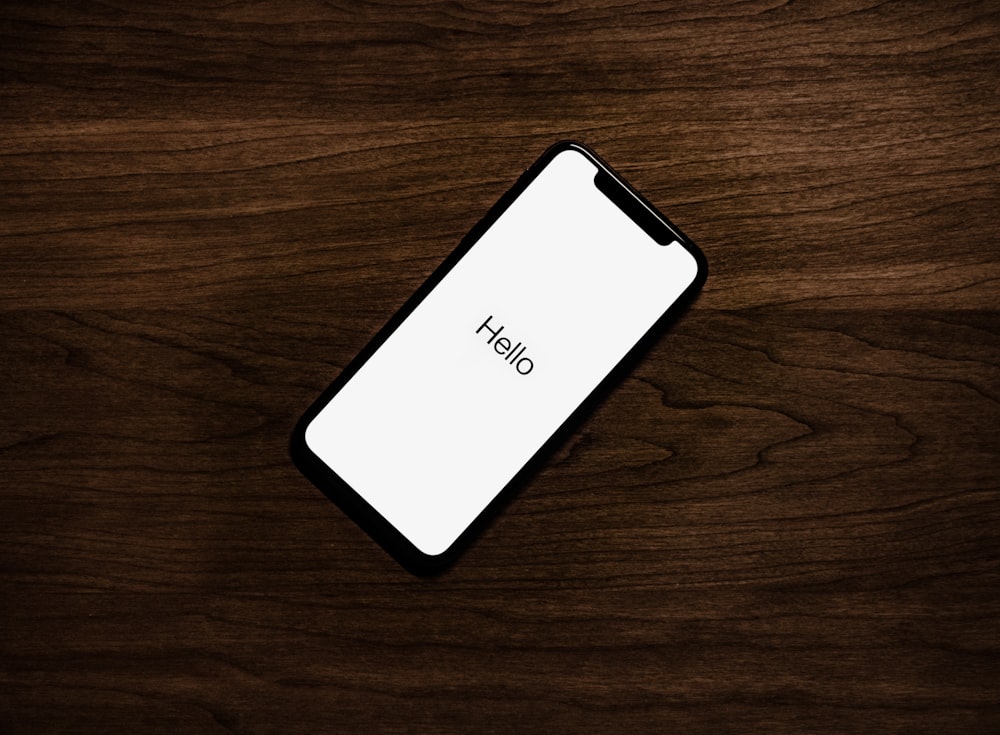 acceso iPhone sopra la superficie di legno marrone