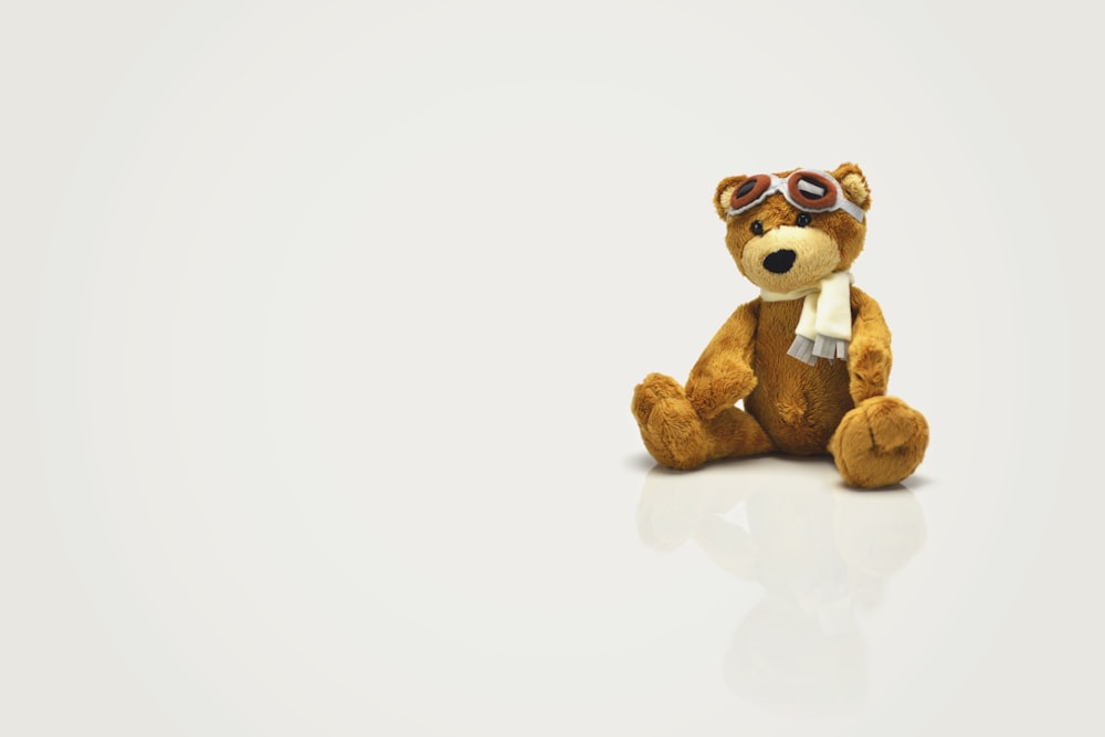 Brinquedo de pelúcia do urso marrom na superfície branca