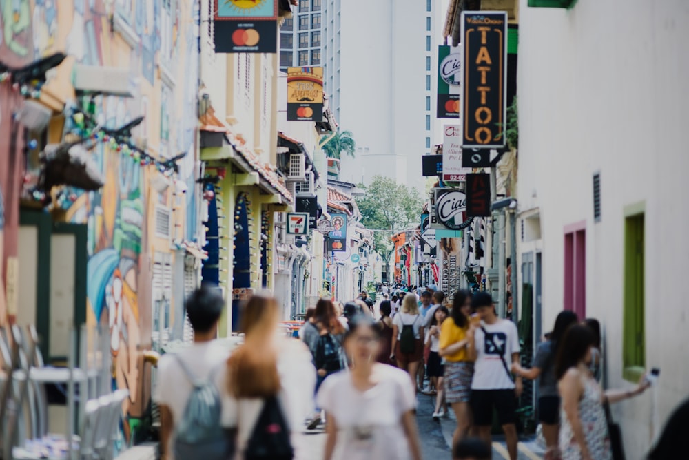 people walking on road between buildings