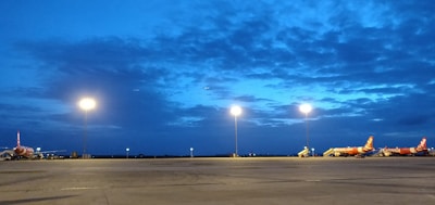 Nighttime shot of multiple fuel tankers lined up at an airport fuel farm, illuminated by ambient lighting.