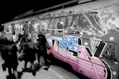 A vibrant graffiti-covered train in a European city, echoing Kende’s street roots.