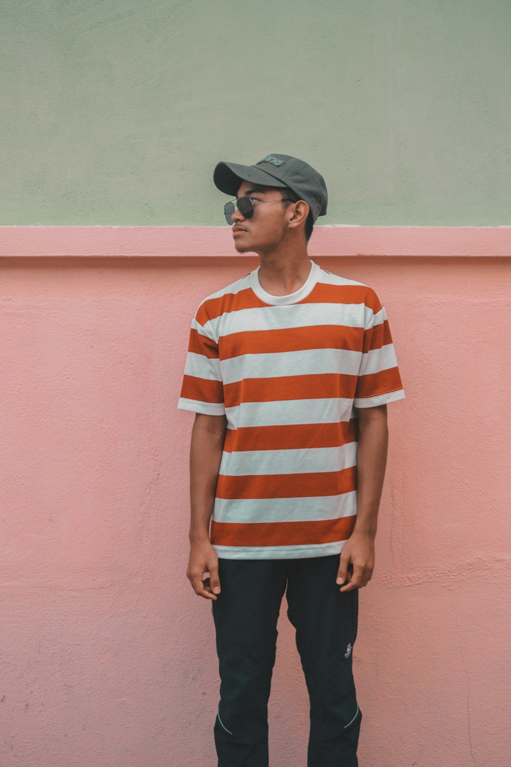 man looking over shoulder near pink wall