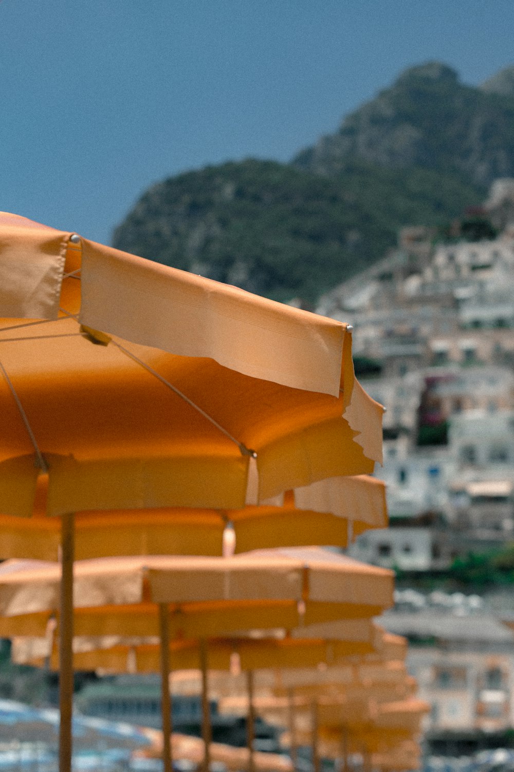 aligned orange patio umbrellas near mountain