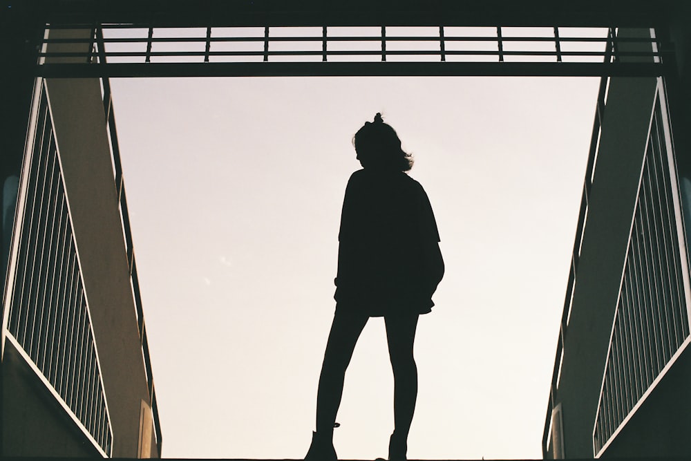 silhouette photo of woman standing on concrete road