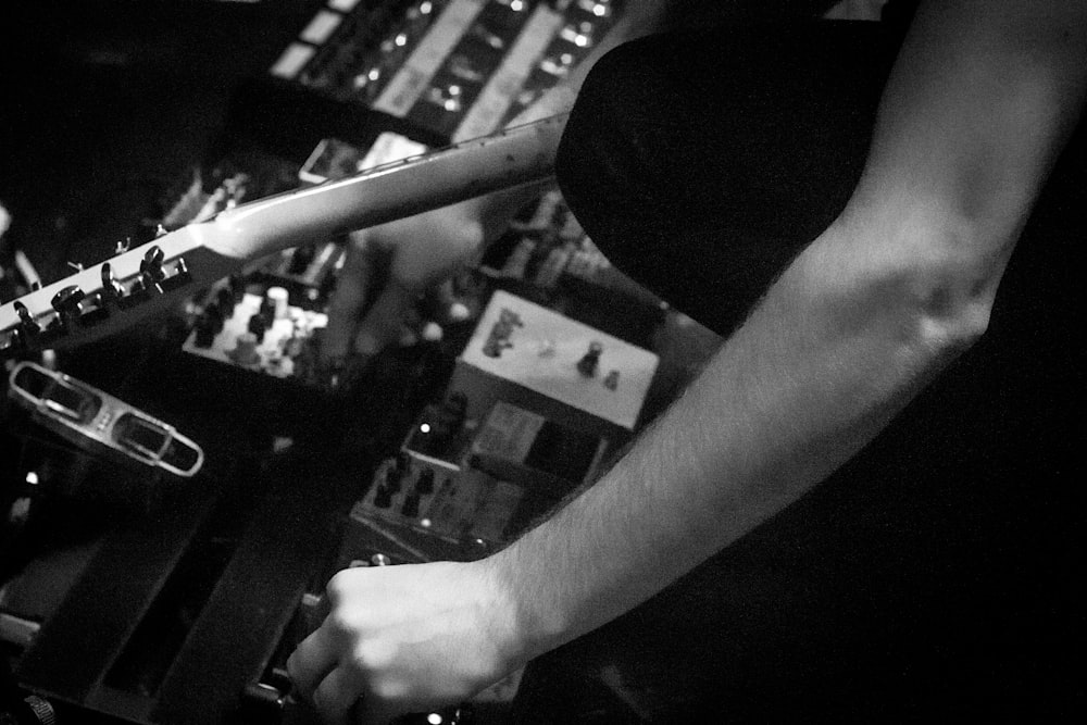 grayscale photography of person holding guitar