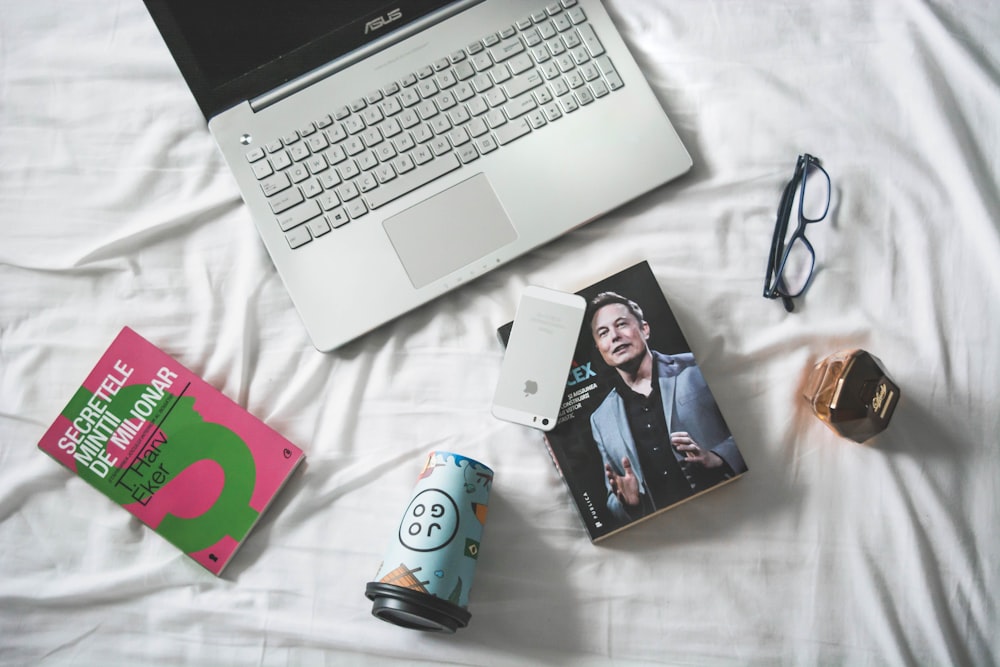fotografia flat lay di MacBook e libro con occhiali da vista