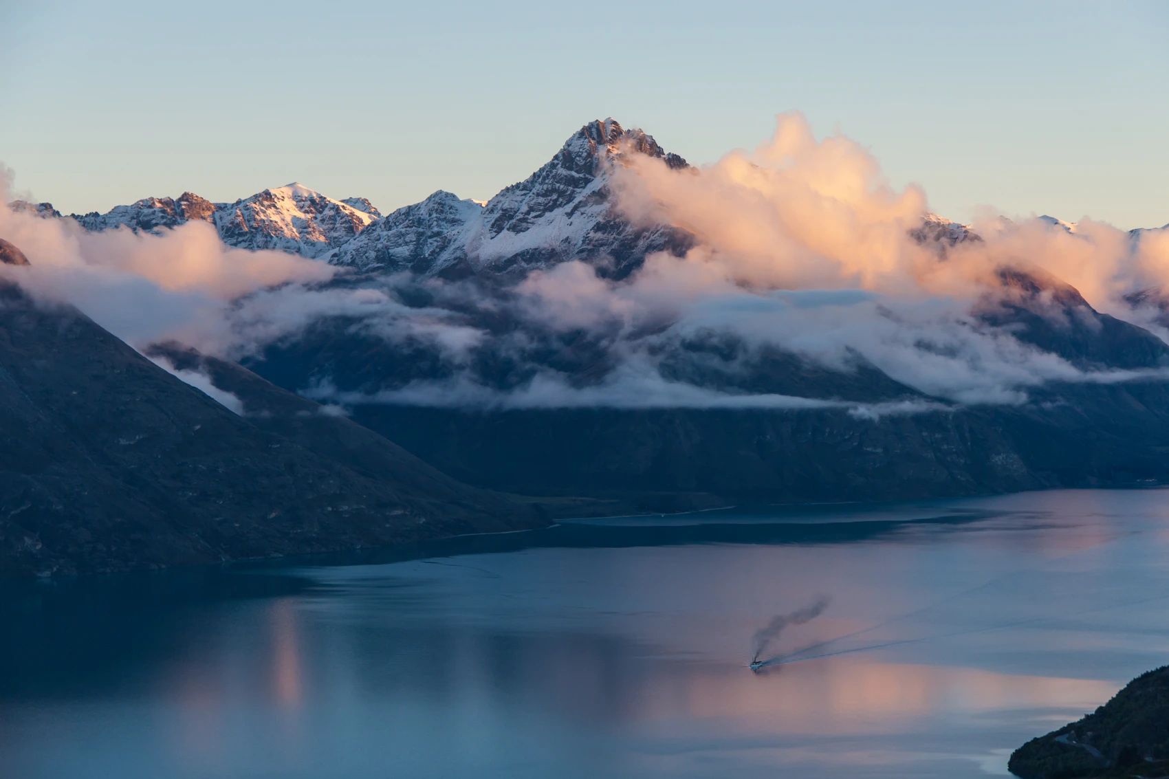 Snow-covered mountains reflected in Lake Whakatipu near Queenstown