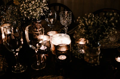 Softly lit personalized candles with delicate gold accents on a cream linen table.