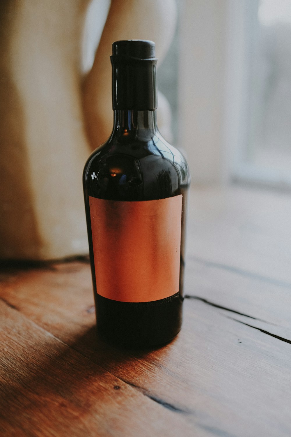 garrafa de vidro marrom na superfície de madeira