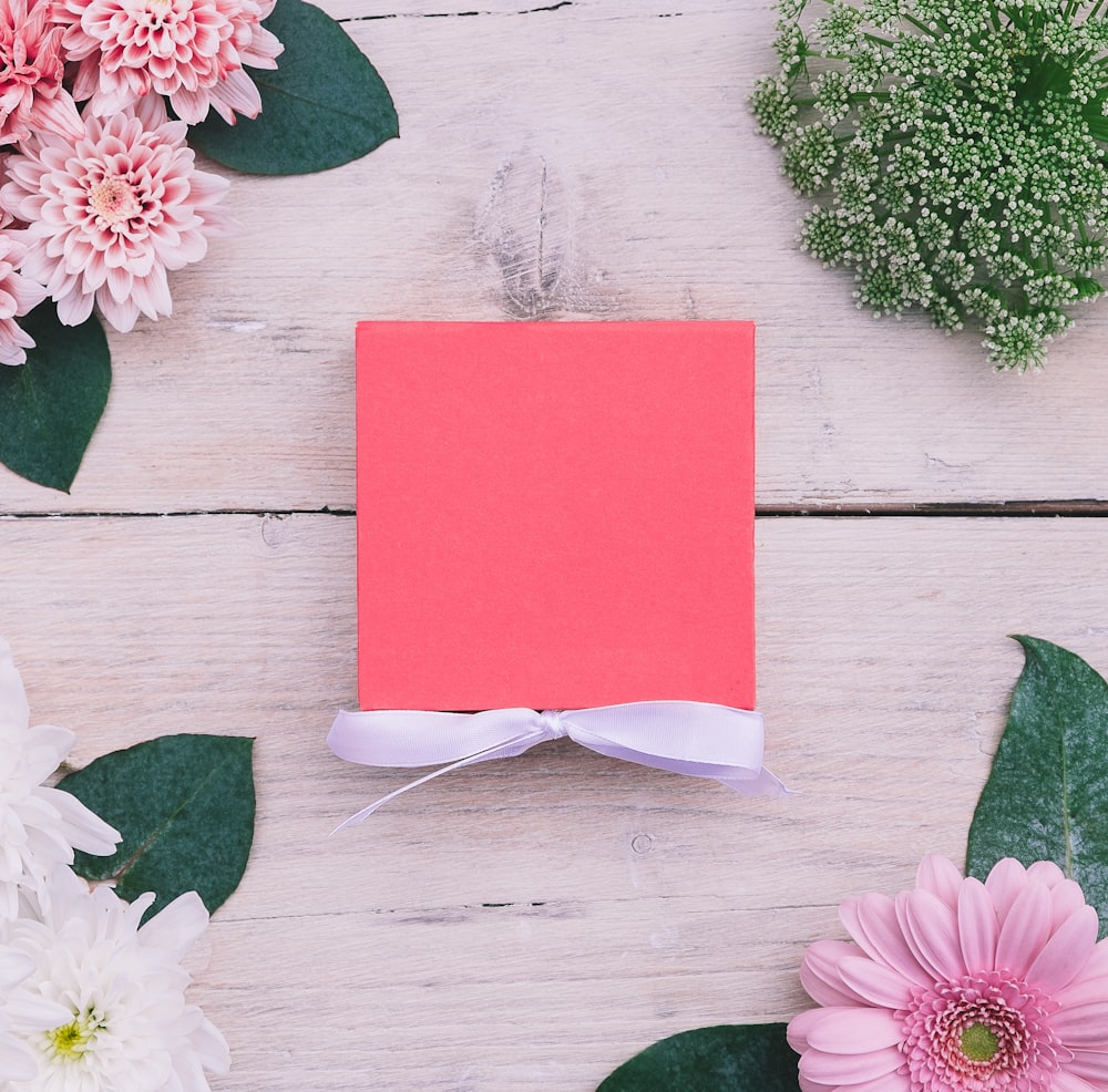 베이지 색 나무 표면에 핑크 카드