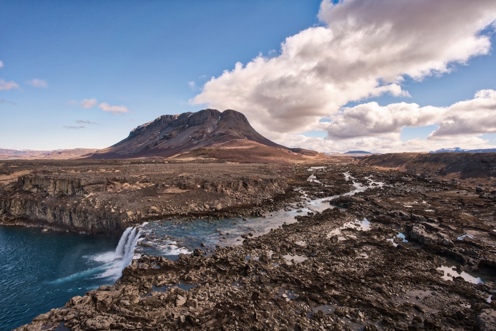 rock formation beside body of water during day time