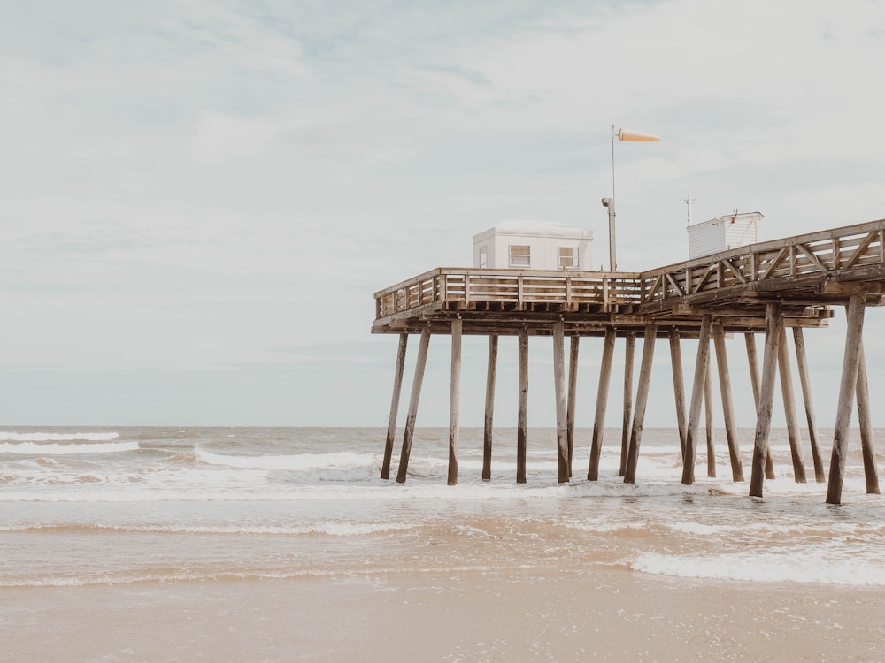 brown wooden dock near shore under cloudy sky