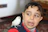 A cheerful 14-year-old boy holding a sushi roll with a colorful swifty bird perched on his shoulder.