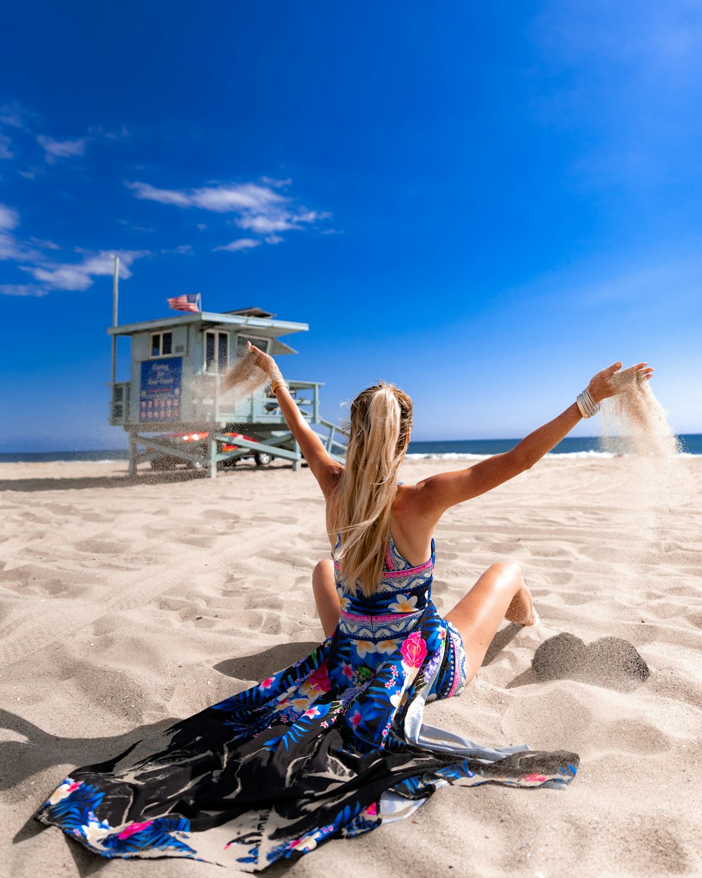 Frau sitzt auf Strandsand