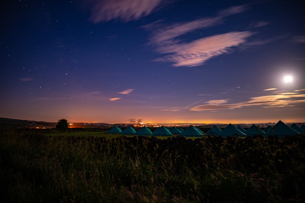 blue tents under white clouds at golden hour