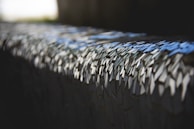 Close-up of a fragmented face portrait with brushed gold accents reflecting light on crystal-clear plexiglass.