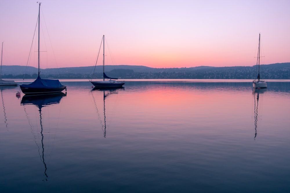 a group of boats floating on top of a lake