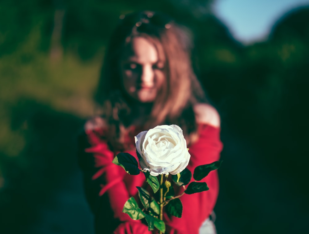 Mujer sosteniendo flor blanca