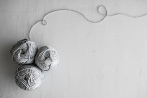 flat lay photography of three white yarn balls