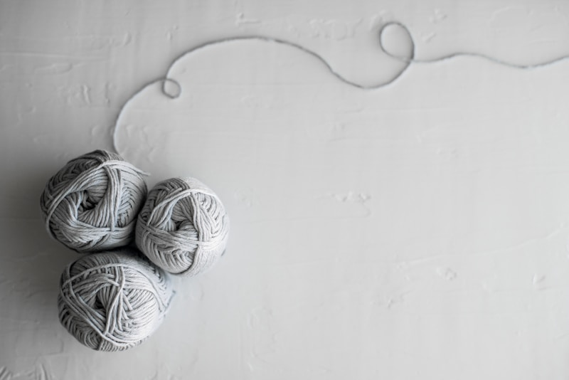 flat lay photography of three white yarn balls