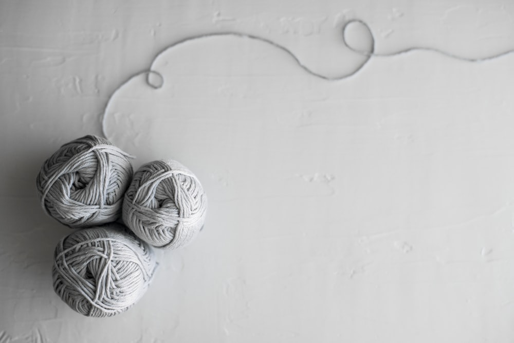 flat lay photography of three white yarn balls