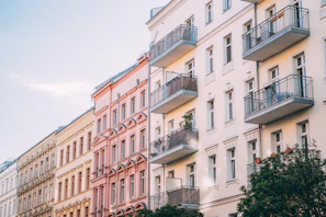 Außenansicht bunter Mehrfamilienhäuser aneinandergereiht. Balkone und Fenster