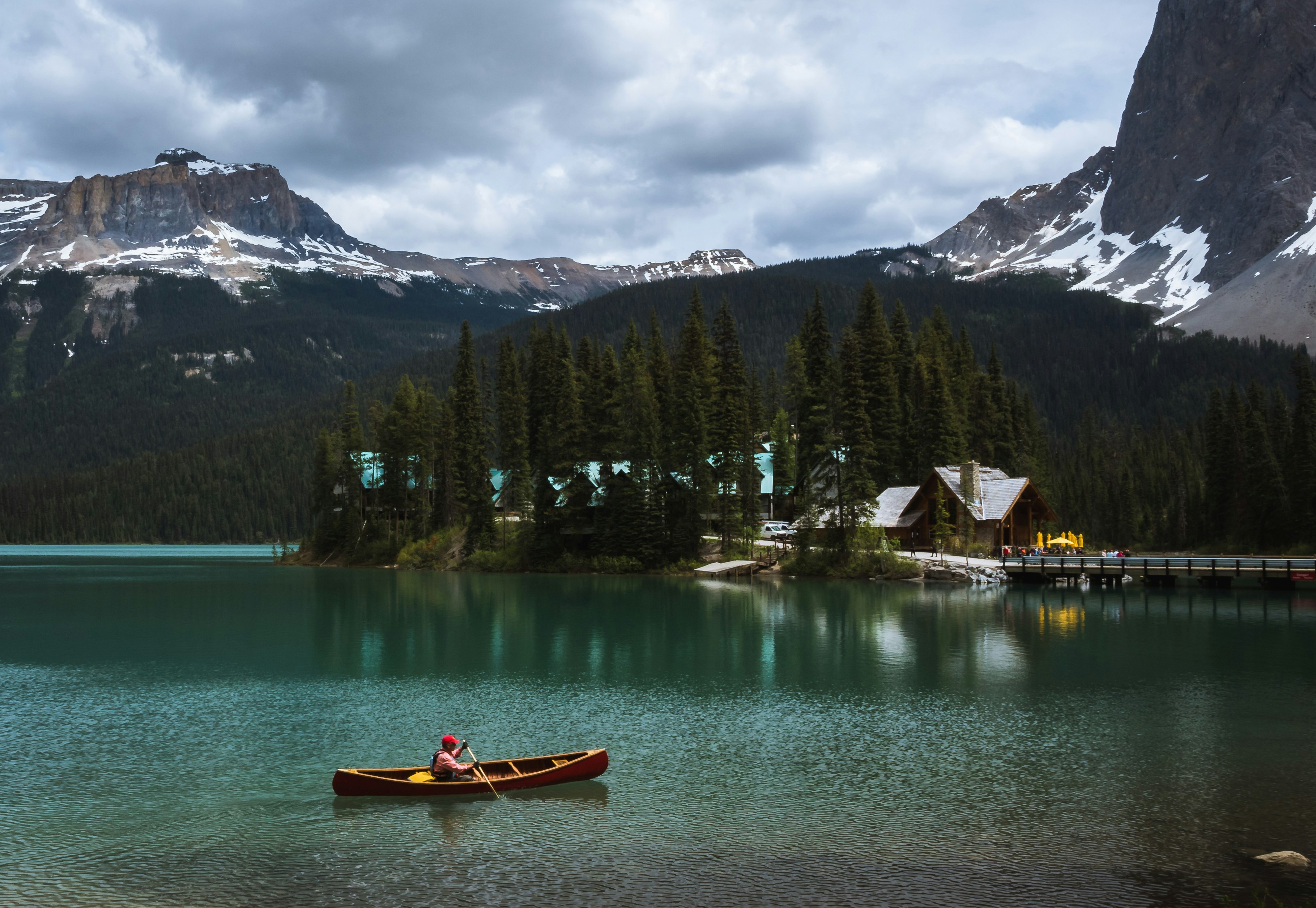 person rowing at lake during cloudy skies