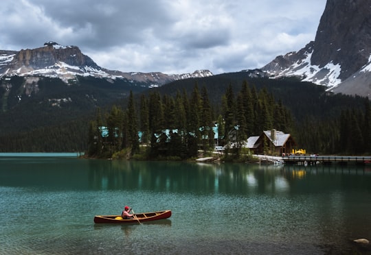 person rowing at lake during cloudy skies in Emerald Lake Canada