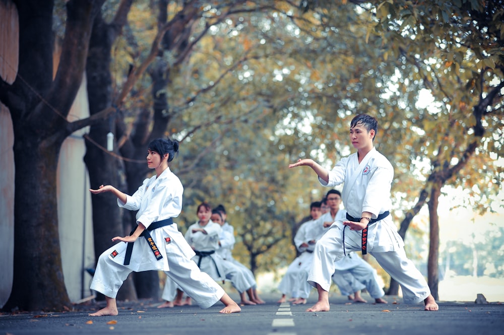 Hombre y mujer haciendo karate en la carretera durante el día