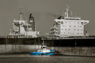A supply vessel delivering fuel and provisions to a merchant ship at sea.
