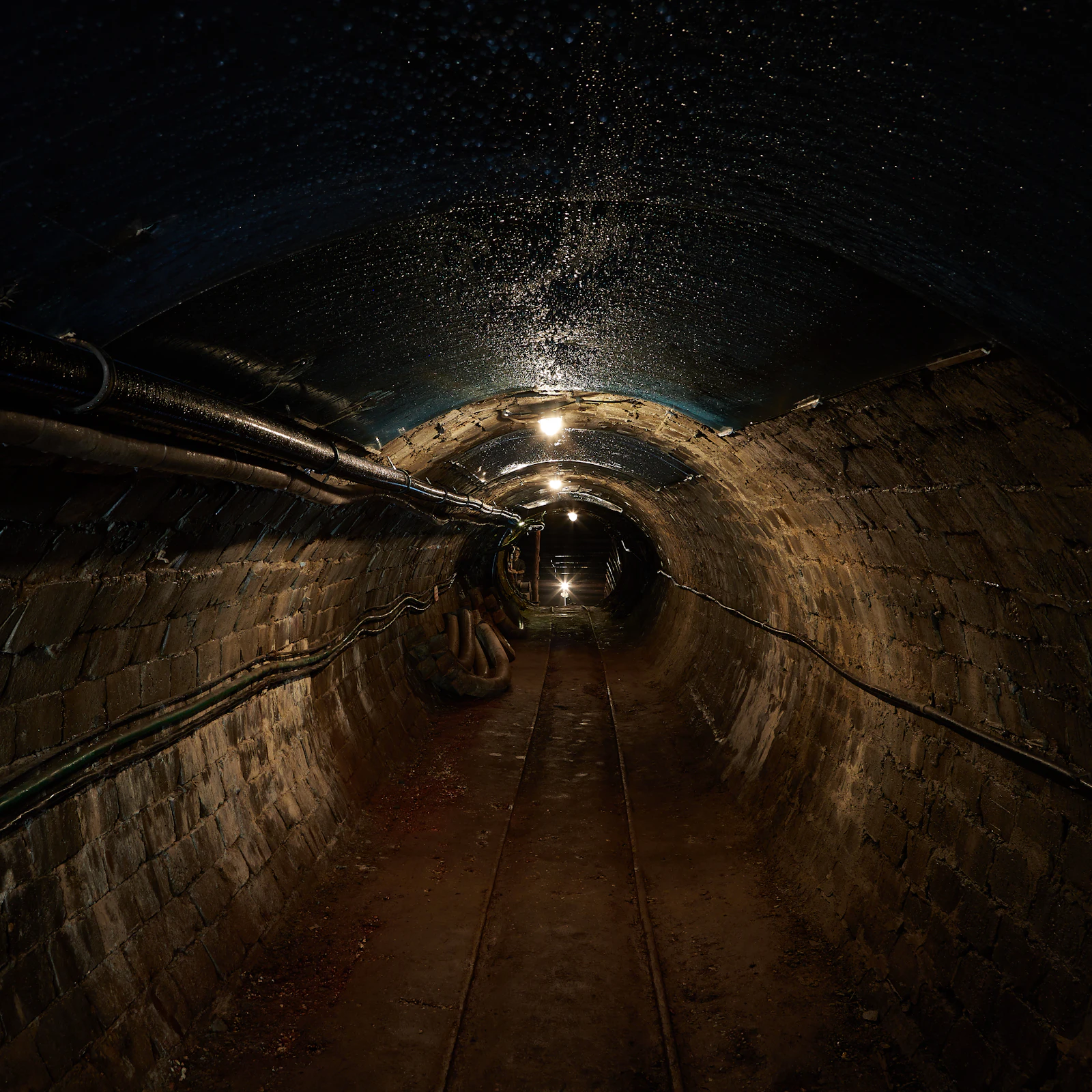 Galerie de mine avec voie étroite s'enfonçant sous la montagne (image d'illustration)