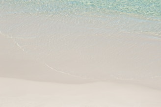 The pristine white sandy beach of Cayo Levantado with turquoise waves gently lapping the shore.