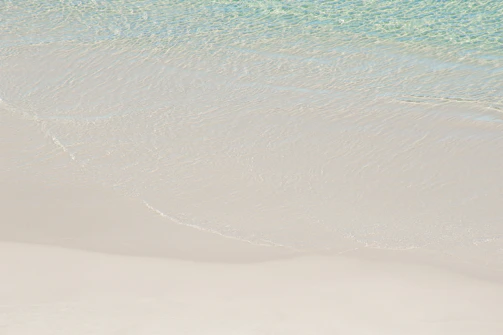 Golden sandy beach with turquoise waves gently rolling ashore.