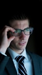 man holding his eyeglasses