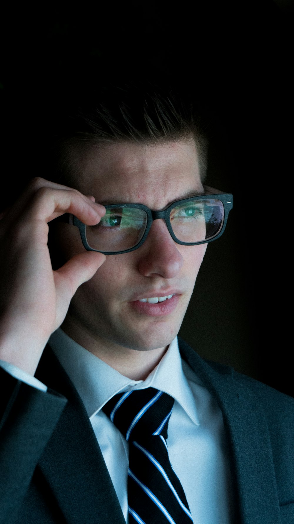 man holding his eyeglasses