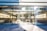 An Apple retail store with large glass windows and a prominent Apple logo above the entrance. Inside, there are wooden tables with electronic devices displayed along with colorful artwork on the walls. The bright, modern space is filled with natural light.