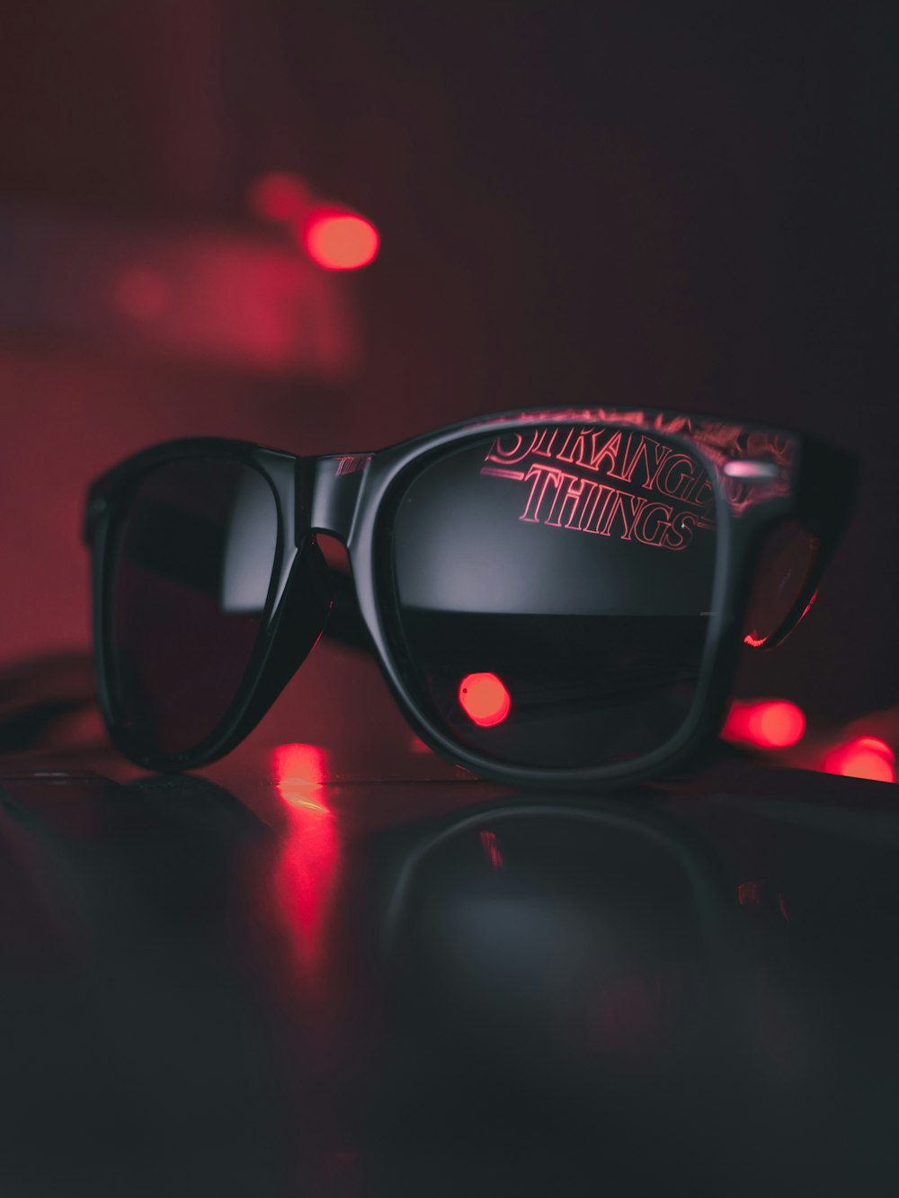 black wayfarer sunglasses on black surface