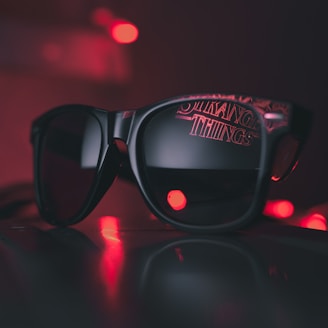 black wayfarer sunglasses on black surface