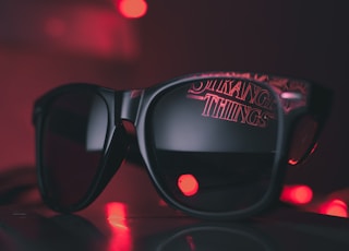 black wayfarer sunglasses on black surface