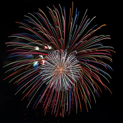 A colorful display of various firecrackers lighting up the night sky in celebration.