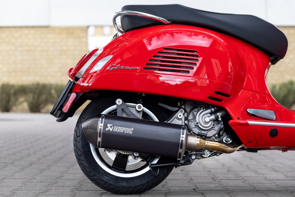 red motor scooter parked on brick floor