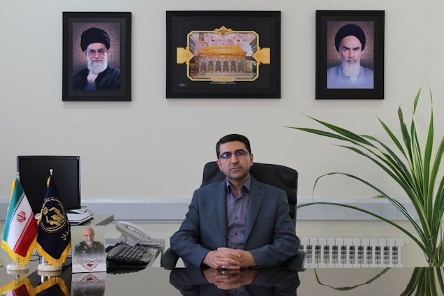A professional portrait of Abdelrahman Rafat working at his desk with marketing materials around.