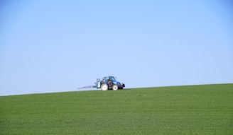 A friendly farmer inspecting a modern tractor in a sunny field.
