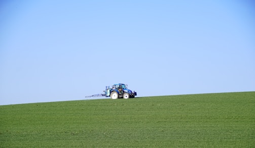 A friendly technician assisting a farmer with agricultural machinery in a sunny field.